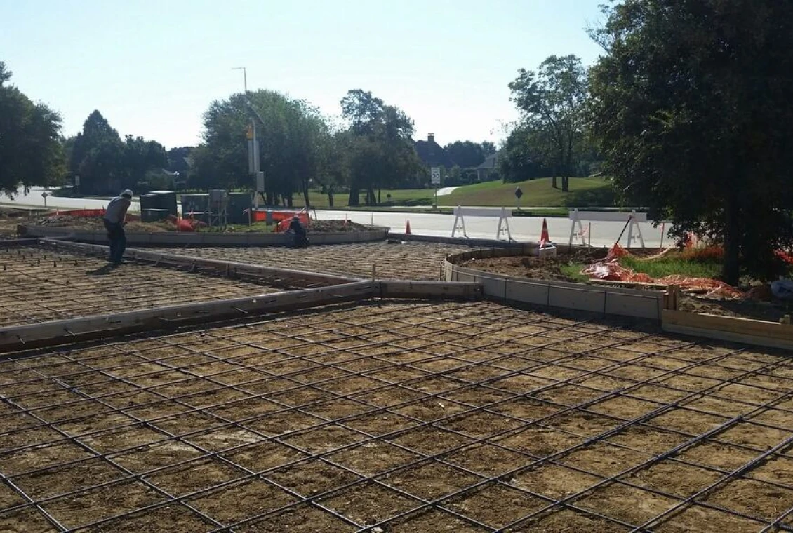 Workers preparing concrete foundation